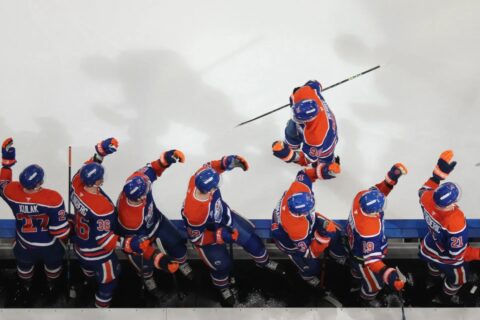 Corey Perry skates by bench, celebrating goal with Edmonton Oilers' players