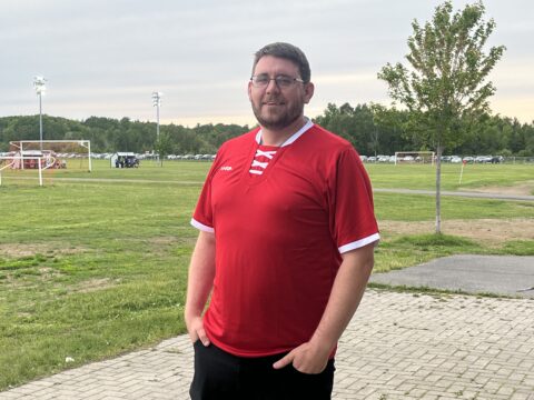 COACH'S SPOTLIGHT | Tim Marsh: From the sidelines to the soul of the game 32 Coach Tim Marsh poses with a red jersey on